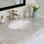 White marble bathroom vanity with undermount sink and brass faucet