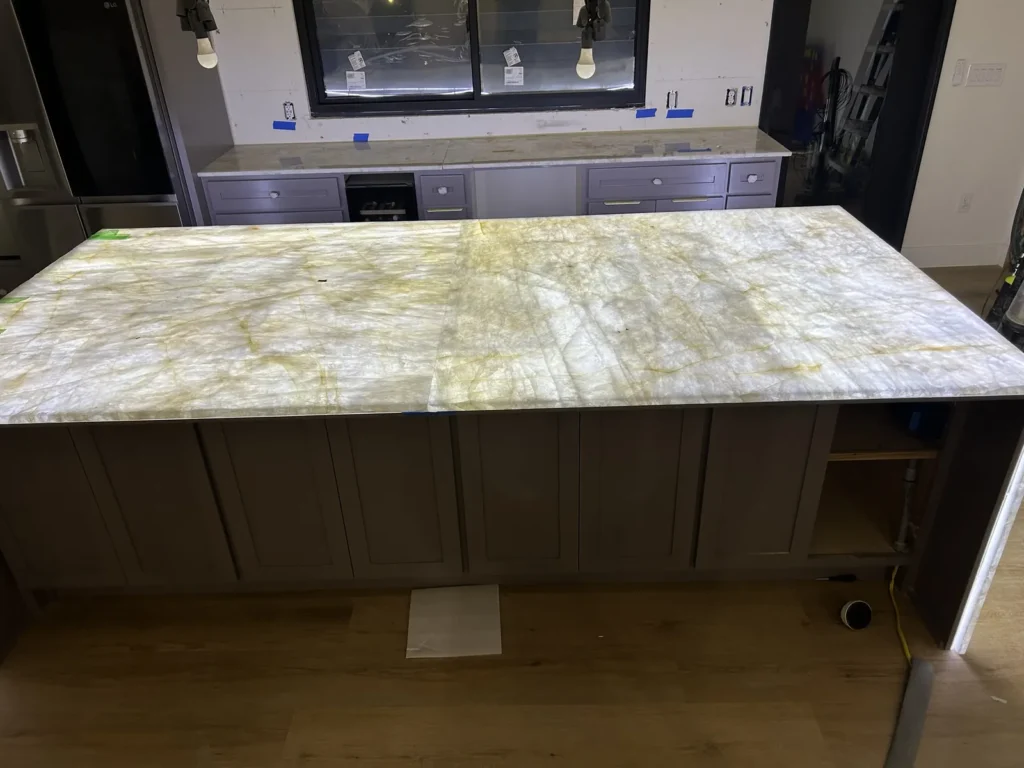 Backlit translucent quartzite kitchen island with waterfall edge, installed by Austin Tops