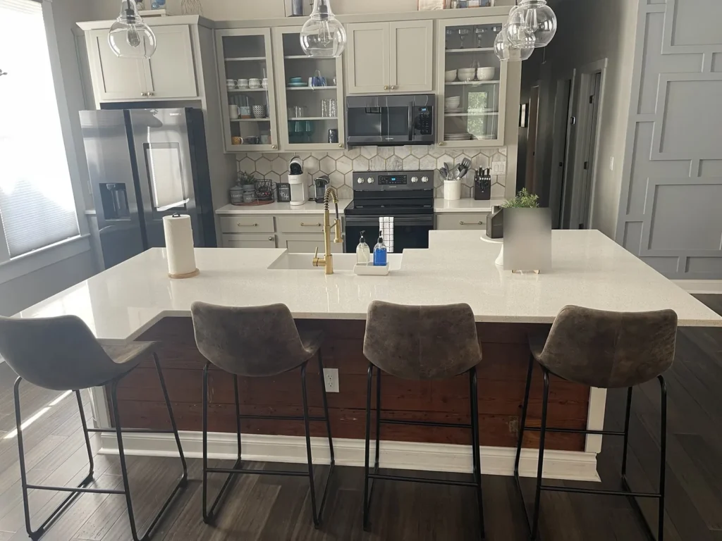 Large white quartz kitchen island with undermount sink and seating for four