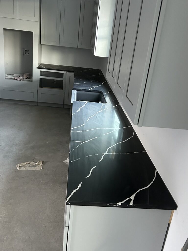 Black quartz countertops with white veining, L-shaped layout, Austin TX
