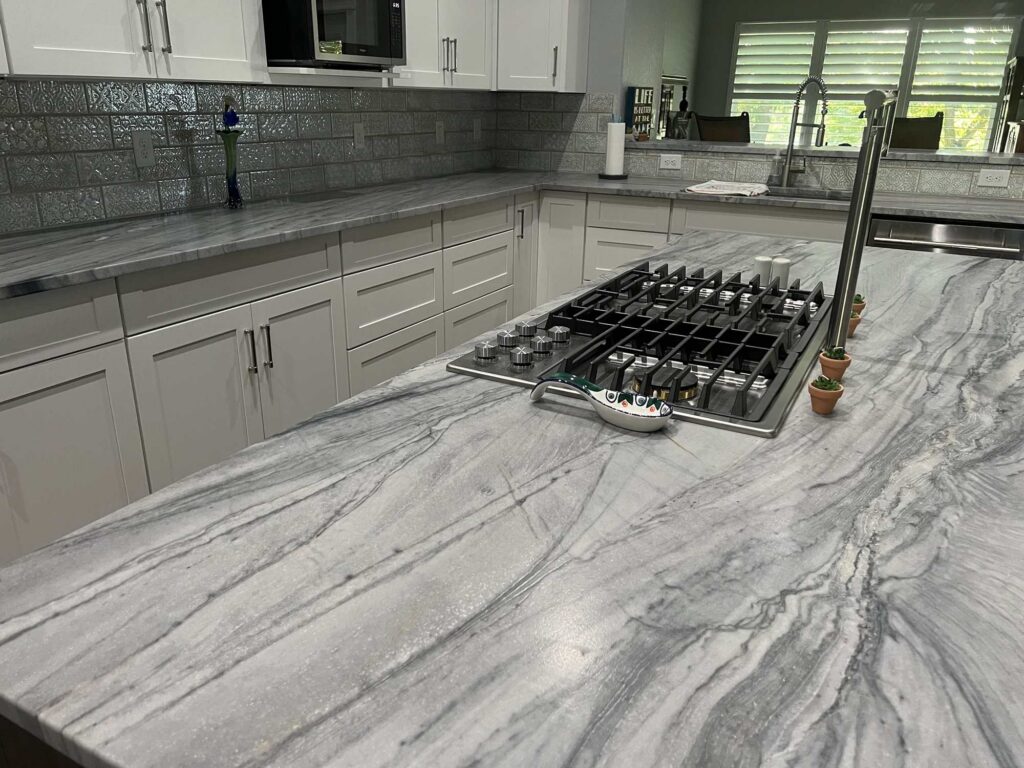 Close-up of gray quartzite island with cooktop cutout, Austin TX
