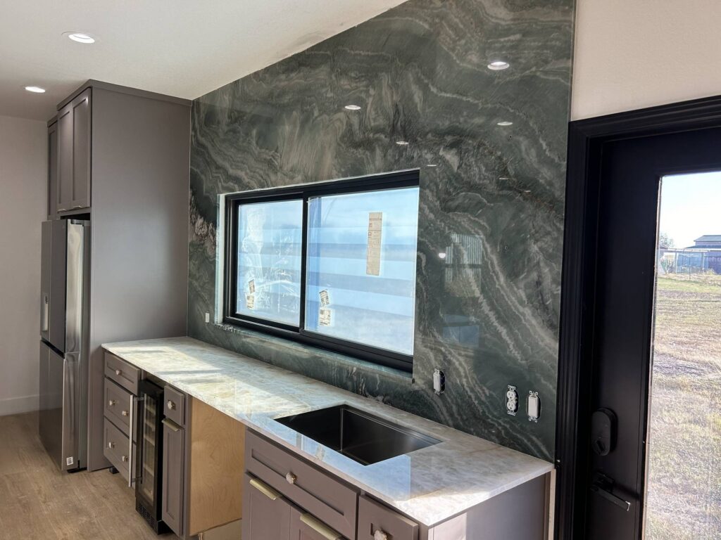 Green quartzite full-height backsplash with white quartzite countertop and undermount sink, Austin TX