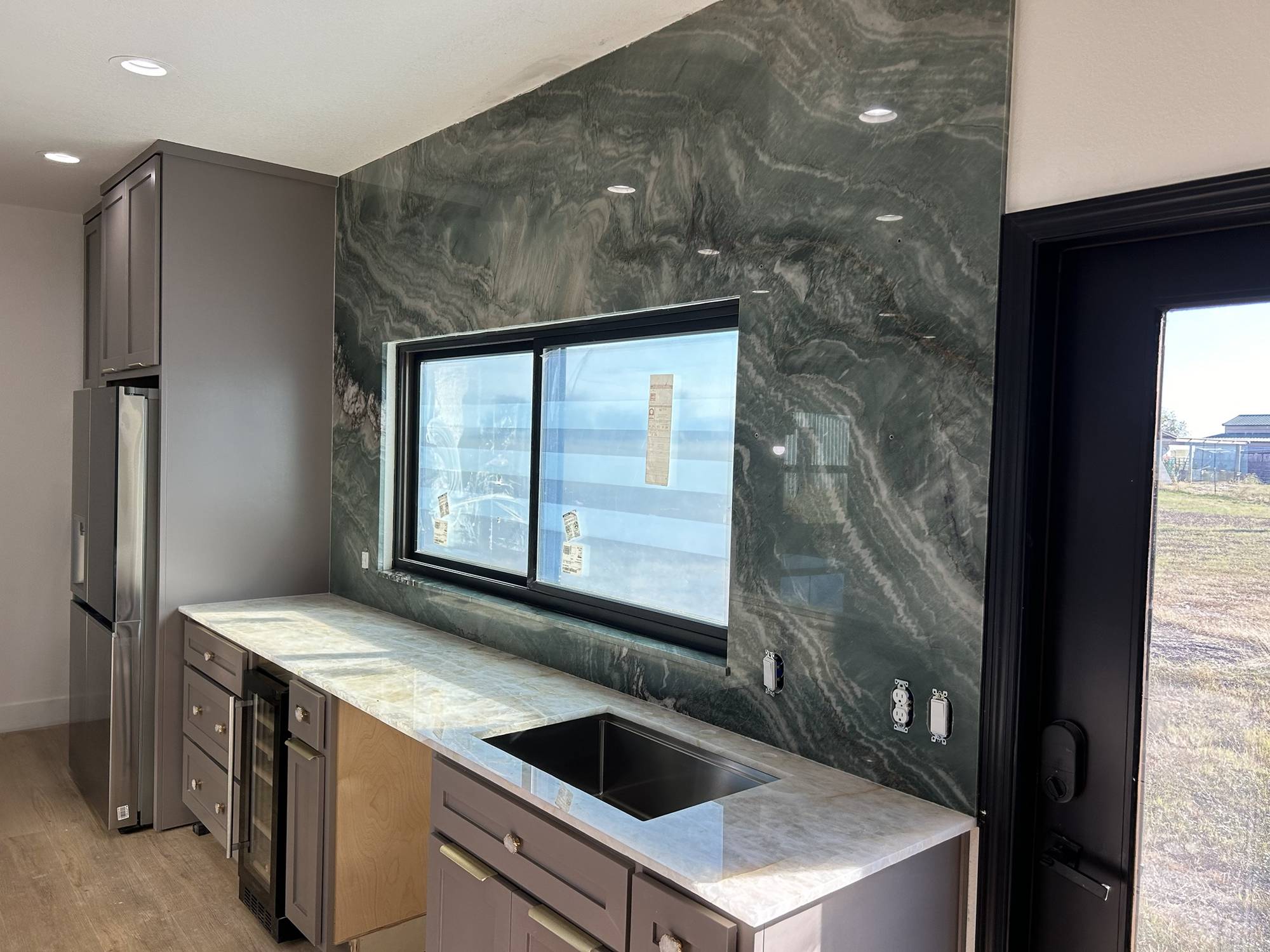 Green quartzite full-height backsplash with white quartzite countertop and undermount sink, Austin TX