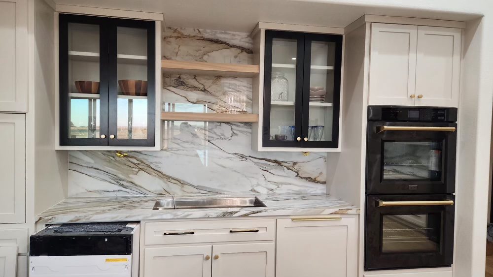 White marble-look countertop with full-height slab backsplash behind floating shelves