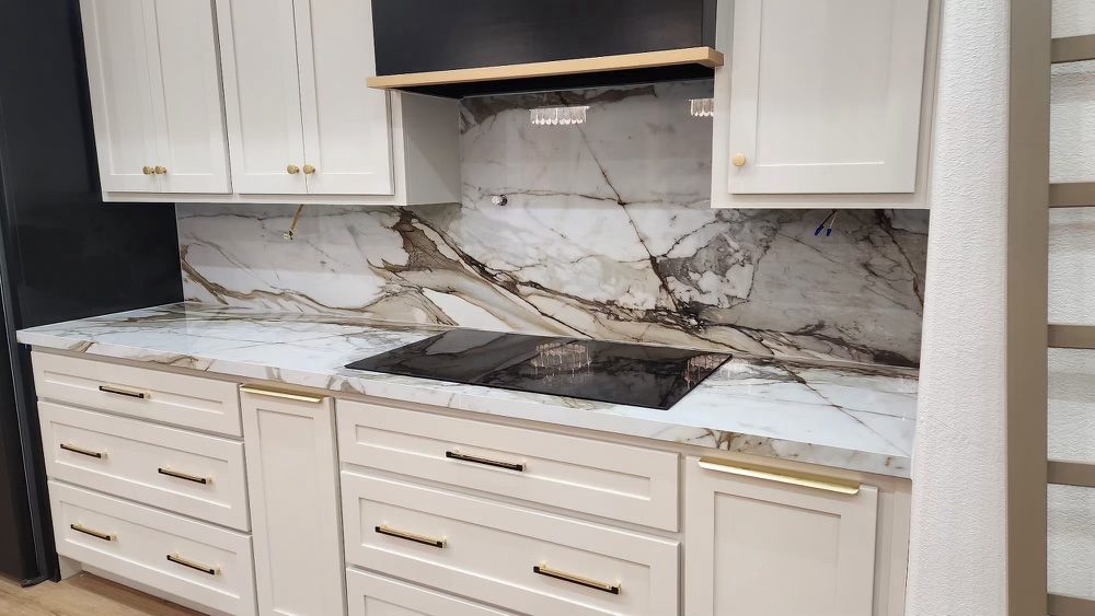 White marble-look slab backsplash and countertop with cooktop