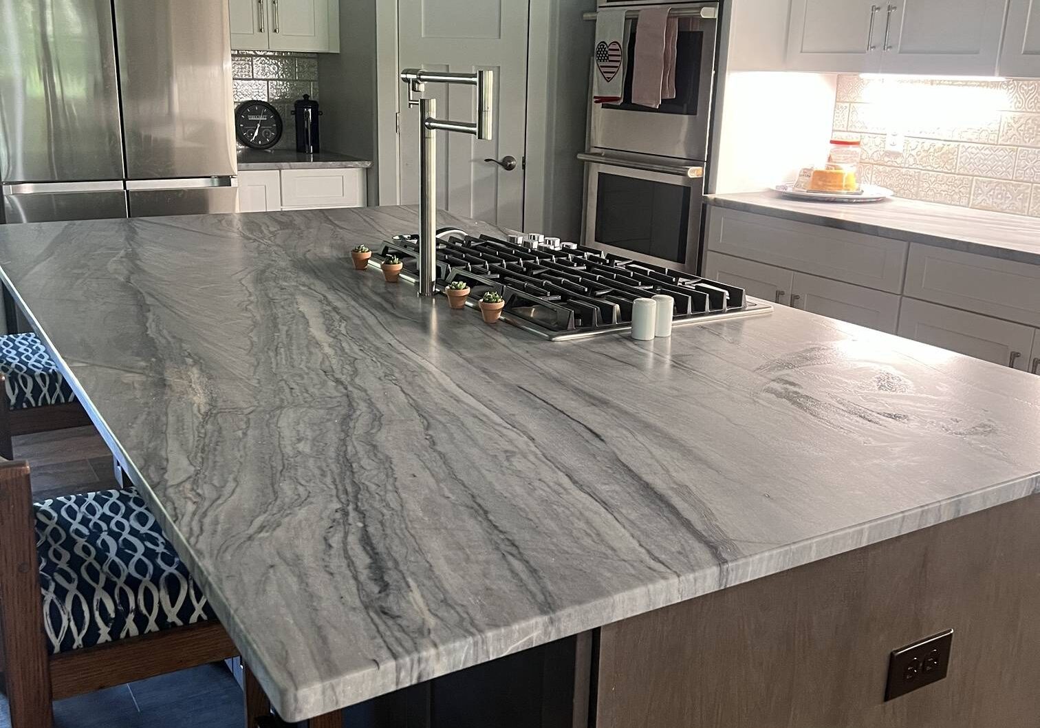 Gray quartzite kitchen island with cooktop and pot filler, Austin TX